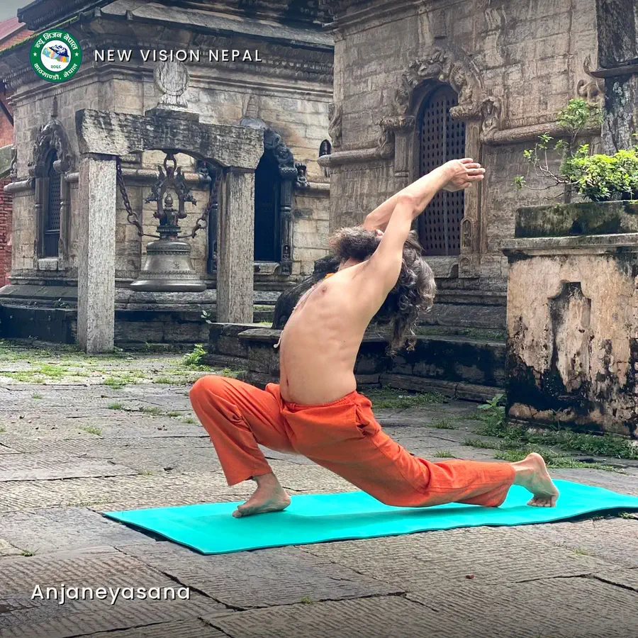 Yogi Ji in a low lunge, the back arched and both arms sweeping overhead, on the paved courtyard before a stone shrine.